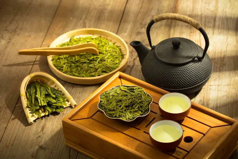 A tea set with a teapot and two cups of green tea
